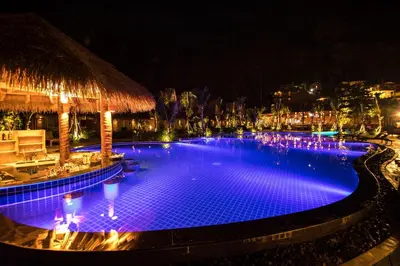 a large swimming pool at night with purple lights at Phi Phi CoCo Beach Resort in Phi Phi Don