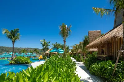 a resort with a pool and palm trees and umbrellas at Phi Phi CoCo Beach Resort in Phi Phi Don