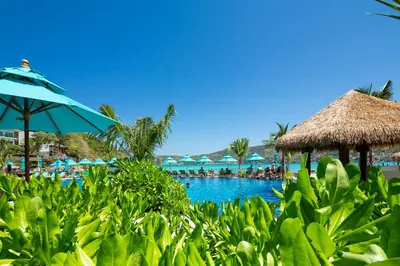 a pool at a resort with a blue umbrella at Phi Phi CoCo Beach Resort in Phi Phi Don