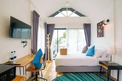 a bedroom with a large bed and a window at The Seaton House in Rawai Beach