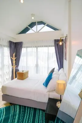 a bedroom with a large bed with a large window at The Seaton House in Rawai Beach