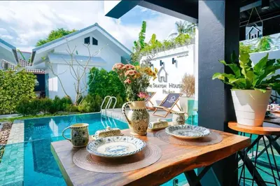 a table with plates and mugs on it on a patio at The Seaton House in Rawai Beach
