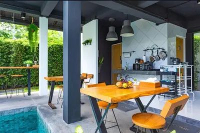 a kitchen and dining room with a table and a pool at The Seaton House in Rawai Beach