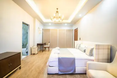 a bedroom with a large white bed and a desk at Nakara Hill Phuket in Chalong