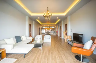 a living room with white furniture and a tv at Nakara Hill Phuket in Chalong