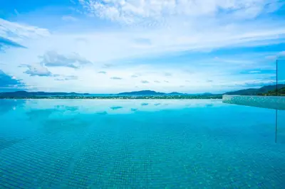 a large swimming pool with a view of the ocean at Nakara Hill Phuket in Chalong