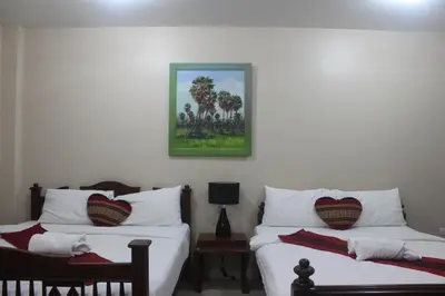 a bedroom with two beds and a picture on the wall at Freedom Kata in Kata Beach