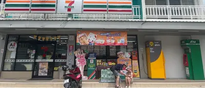a man sitting on a scooter in front of a store at Freedom Kata in Kata Beach