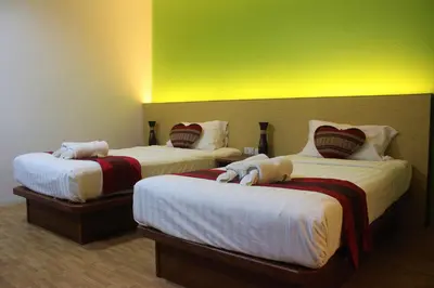 a hotel room with two beds and a green wall at Freedom Kata in Kata Beach