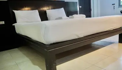 a large bed with white sheets and pillows on it at Orm Thong Hotel - SHA Plus in Kathu