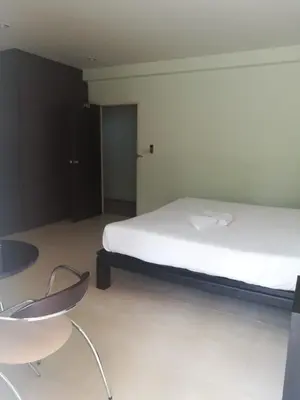 a bedroom with a bed and a table and a chair at Orm Thong Hotel - SHA Plus in Kathu