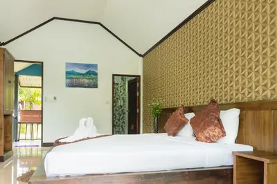 a bedroom with a large white bed in a room at Baannai Lake View Resort in Ao Nang Beach