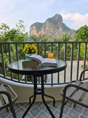 a table with a book and a drink on a balcony at Baannai Lake View Resort in Ao Nang Beach