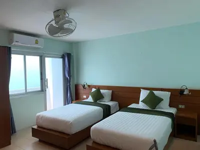 a bedroom with two beds and a window at saithong guesthouse in Rawai Beach