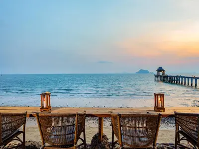 a table on the beach with chairs and a pier at Santhiya Koh Yao Yai Resort & Spa - Compulsory Join Santhiya Speedboat from-to Ao Po Grand Marina at Phuket in Ko Yao Yai