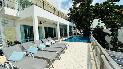 a row of chaise lounge chairs next to a swimming pool at Villa Ginborn amazing 5-Bedroom Sea-View Pool Villa 5 Minutes to Kata Beach in Kata Beach