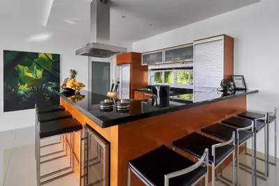 a kitchen with a counter with stools around it at Villa Ginborn amazing 5-Bedroom Sea-View Pool Villa 5 Minutes to Kata Beach in Kata Beach