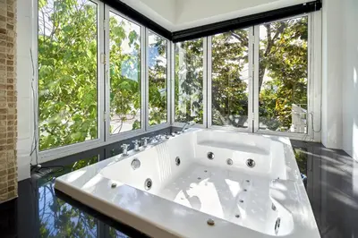 a large white bath tub in a room with windows at Villa Ginborn amazing 5-Bedroom Sea-View Pool Villa 5 Minutes to Kata Beach in Kata Beach