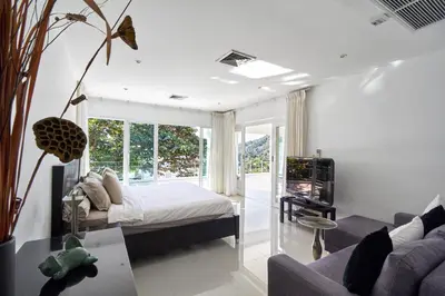 a bedroom with a bed and a living room at Villa Ginborn amazing 5-Bedroom Sea-View Pool Villa 5 Minutes to Kata Beach in Kata Beach