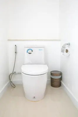 a white bathroom with a toilet in a room at Purana Resort Koh Yao Noi - SHA Extra plus in Ko Yao Noi