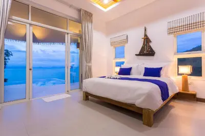 a bedroom with a bed with a view of the ocean at Purana Resort Koh Yao Noi - SHA Extra plus in Ko Yao Noi