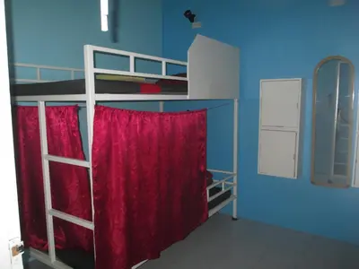 a bedroom with two bunk beds with red curtains at Rehab Hostel in Phi Phi Don