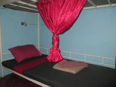 a bedroom with a bed with a red curtain at Rehab Hostel in Phi Phi Don