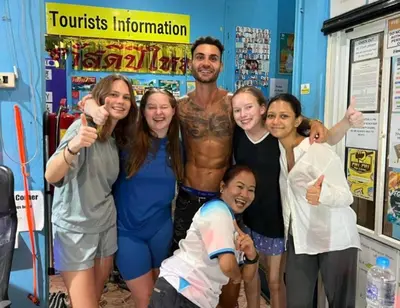a man with a group of people posing for a picture at Rehab Hostel in Phi Phi Don