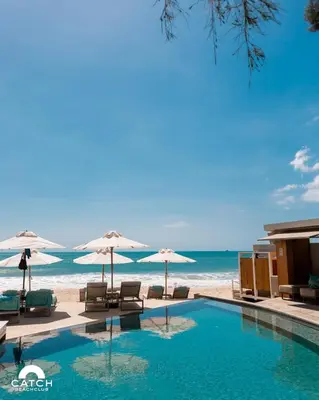 a swimming pool next to the beach with umbrellas at Perfect 2br Pool Villa In Residence Bangtao Beach4 in Bang Tao Beach