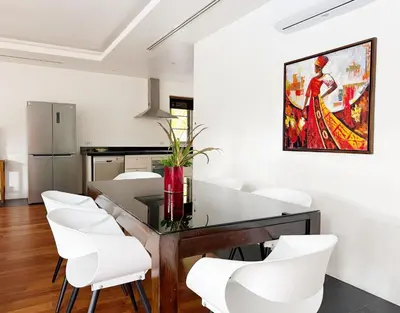 a dining room with a table and white chairs at Perfect 2br Pool Villa In Residence Bangtao Beach4 in Bang Tao Beach