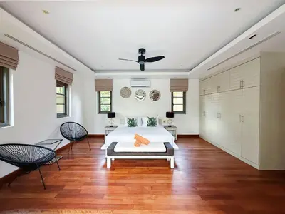 a bedroom with a bed and two chairs and a ceiling at Perfect 2br Pool Villa In Residence Bangtao Beach4 in Bang Tao Beach