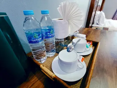 a tray with two bottles of water and two cups at The Guest House - Apartment in Patong Beach