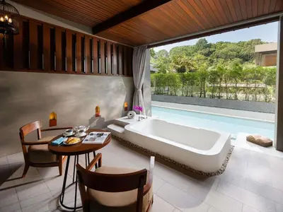 a bathroom with a tub and a table and a dining room at Avista Hideaway Phuket Patong - MGallery in Patong Beach