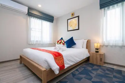 a bedroom with a large bed with two teddy bears on it at The Title Residencies Naiyang Pool View in Nai Yang Beach
