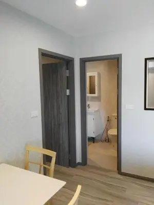 a room with a door and a table and a bathroom at The Title Residencies Naiyang Pool View in Nai Yang Beach