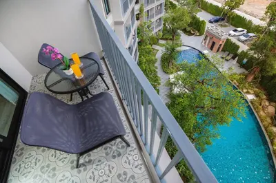 an apartment balcony with a table and a swimming pool at The Title Residencies Naiyang Pool View in Nai Yang Beach