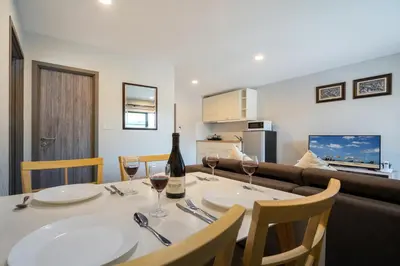a dining room with a table with two glasses of wine at The Title Residencies Naiyang Pool View in Nai Yang Beach