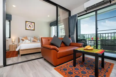 a living room with a couch and a bed at The Beach Residence by EHM in Nai Yang Beach