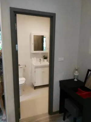 a bathroom with a toilet and a sink and a mirror at The Beach Residence by EHM in Nai Yang Beach