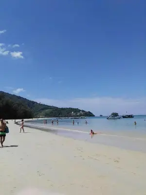 a group of people walking on the beach at The Beach Residence by EHM in Nai Yang Beach