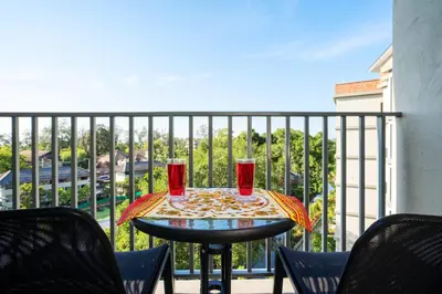 a table with two wine glasses on a balcony at The Beach Residence by EHM in Nai Yang Beach