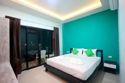 a bedroom with a large bed with a blue wall at The Aireen Hotel in Ao Nang Beach