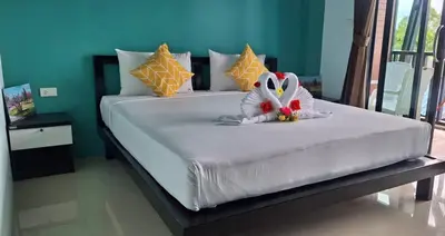 a large white bed with a stuffed animal on it at The Aireen Hotel in Ao Nang Beach