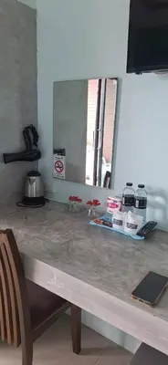a counter in a kitchen with a table and a mirror at The Aireen Hotel in Ao Nang Beach