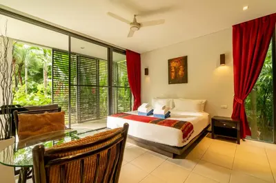 a bedroom with a bed and a glass table at Bangtao Beach Garden by RESAVA in Bang Tao Beach