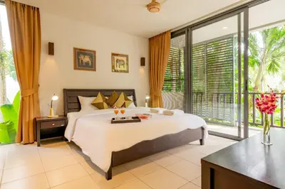 a bedroom with a large bed and a large window at Bangtao Beach Garden by RESAVA in Bang Tao Beach