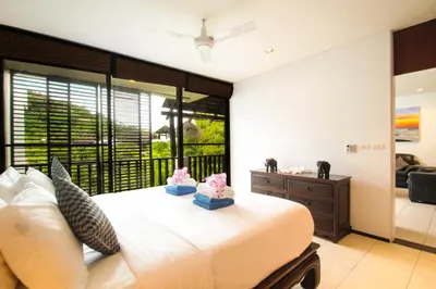a bedroom with a bed and a large window at Bangtao Beach Garden by RESAVA in Bang Tao Beach