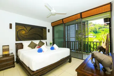 a bedroom with a bed and an elephant on a table at Bangtao Beach Garden by RESAVA in Bang Tao Beach