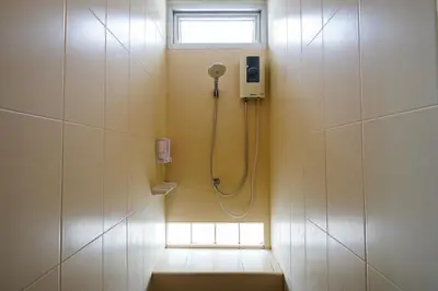 a shower in a bathroom with a window at OK Phuket in Kata Beach