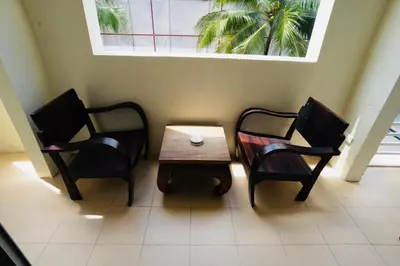two chairs and a table in a room with a window at OK Phuket in Kata Beach